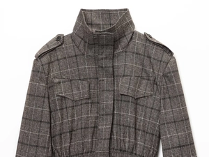 Detail of grey plaid jacket featuring high collar epaulettes and buttoned chest pockets