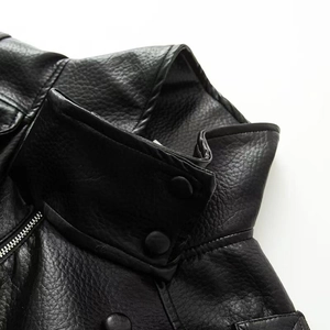 Detail of black pebbled leather jacket collar featuring snap buttons and metal zipper