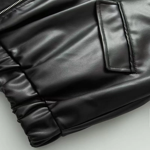 Détail de la poche zippée en métal et de l'ourlet élastique sur veste en cuir noir