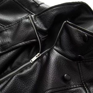 Detailed macro view of black leather jacket featuring metallic zippers and lychee texture