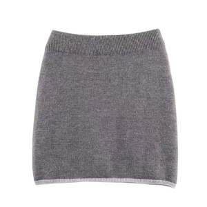 Détail d'une jupe grise en maille avec taille haute élastique et bordure contrastée