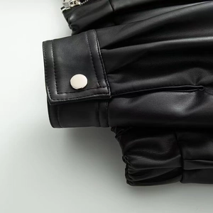 Détail du poignet d'une veste en cuir noir avec bouton-pression métallique argenté