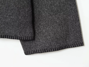 Detailaufnahme der dunkelgrauen Stoffstruktur mit hochwertiger schwarzer Overlock-Nahtkante