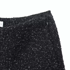 Detail of black tweed fabric texture with side invisible zipper on elegant high waist skirt