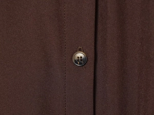 Detailed view of coffee brown shirt dress fabric with a tortoise-shell resin button