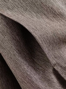 Detailaufnahme der grauen Fischgräten-Wollstofftextur einer Pilotjacke