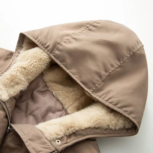 Detail of khaki hooded jacket featuring soft beige faux fur lining and metal zipper closure