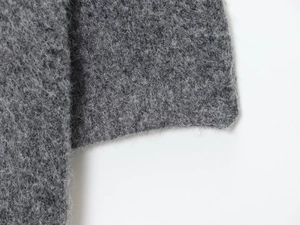 Macro detail of dark grey plush knit fabric showing thick fluffy texture for winter wear