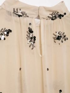 Detail of sequin embroidery on beige chiffon blouse featuring a stand collar design
