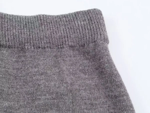 Vue macro de la texture en maille grise et du détail de la taille sur l'ensemble jupe