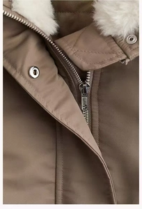 Macro detail of high-quality metal zipper and fluffy faux fur collar on winter parka