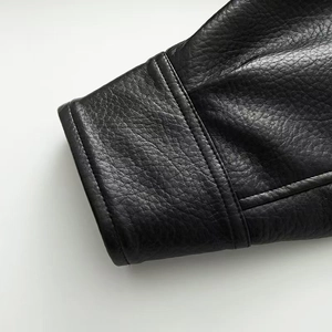 Close-up of black leather jacket sleeve with premium grain texture and double stitching