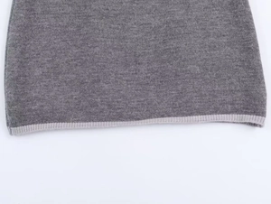 Détail de la manchette en tricot gris avec bordure côtelée gris clair de haute qualité