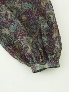 Detail of metallic thread paisley print fabric with gathered cuff on a mini dress