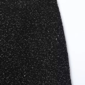 Detailed close-up of premium black and white textured tweed fabric for autumn winter suits