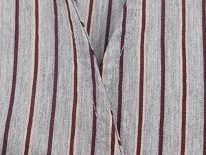 Close-up of striped fabric texture showing grey, burgundy, and off-white woven details