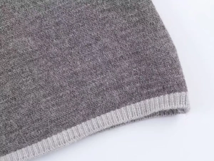 Gros plan sur le tissu en maille grise minimaliste montrant une texture de qualité