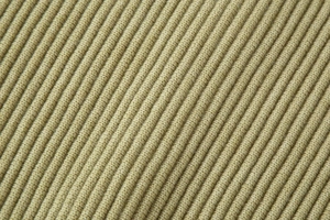 Macro detail of khaki ribbed knit fabric showing soft texture and high-quality yarn fibers