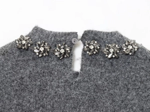 Close-up of grey mohair knit top neckline featuring elegant crystal flower embellishments