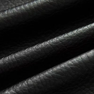 Close-up detail showing the natural grain and texture of the black faux leather jacket fabric