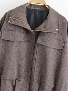 Detail der braunen Bomberjacke mit Fischgrätenmuster, Metall-Reißverschluss und Taschen