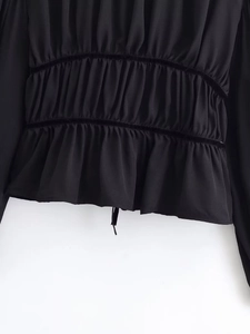 Detail of black chiffon blouse showing ruched waist and parallel velvet ribbon accents