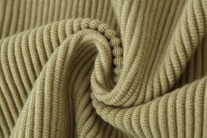 Macro shot of khaki ribbed knit fabric showing thick texture and premium wool material