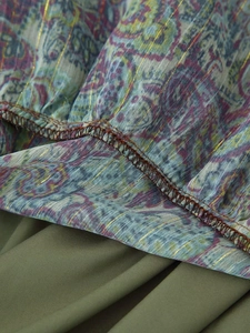 Detail of paisley print chiffon fabric with golden metallic thread and olive green seam