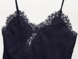 Close-up of deep navy satin camisole featuring delicate black eyelash lace V-neckline