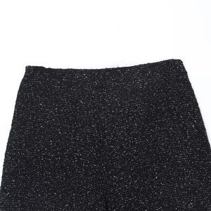 Detail shot of black tweed high-waist skirt-shorts showing thick textured fabric weave