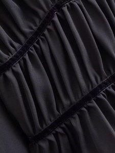 Detail of elegant black pleated chiffon fabric with luxury velvet ribbon accents