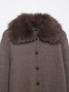 Close-up of brown knit cardigan featuring a textured faux fur collar and round buttons