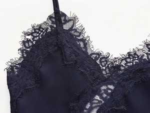Close-up of midnight blue satin camisole with detailed eyelash lace trim and thin straps