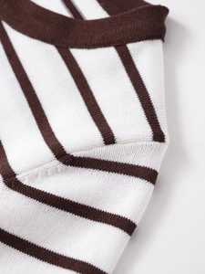 Detailed macro view of the brown and white striped knit texture with a ribbed neckline