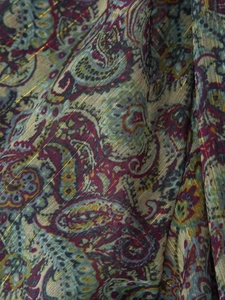 Macro detail of paisley print chiffon fabric with woven golden metallic lurex threads