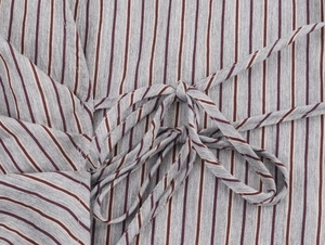 Detail of striped shirt fabric showing textured vertical lines and a knotted side tie