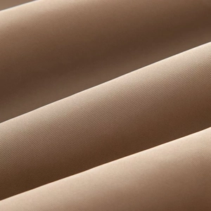 Macro detail of high-density khaki knit fabric showing fine cross-weave texture for winter coat