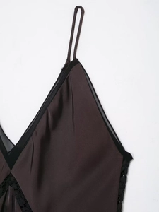 Close-up of deep brown satin slip dress featuring V-neckline with black lace trim and mesh