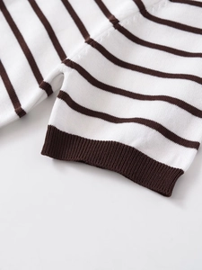 Close-up of ribbed cuffs and striped knit fabric on a minimalist striped sweater