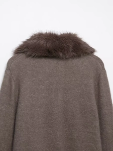 Detail view of the thick brown knit fabric and fluffy faux fur collar on the cardigan
