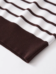 Close-up detail of white and dark brown striped knit fabric with ribbed hem finish