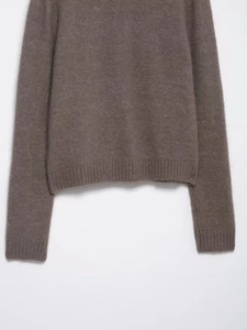 Detail of dark brown knit cardigan showing the ribbed hem and soft cashmere-like texture
