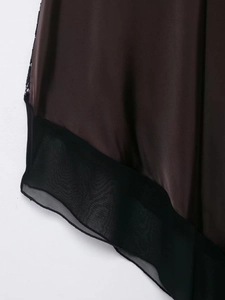 Detail of silk satin dress with chiffon patchwork and delicate black lace trim