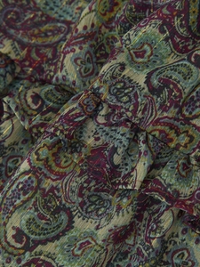 Detailed macro view of the metallic thread and paisley print on the mini dress fabric