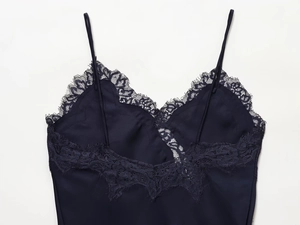 Detail of navy blue satin camisole top featuring delicate eyelash lace trim and thin straps