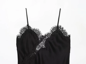 Detailed view of black satin camisole featuring delicate eyelash lace trim and thin straps
