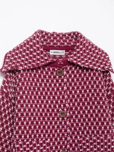 Detail of the burgundy knitted cardigan collar with wood buttons and brand label