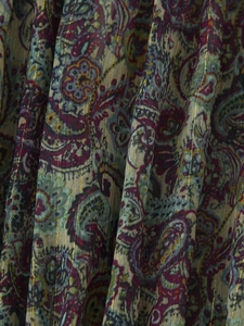 Macro shot of paisley print fabric with golden metallic Lurex stripes on dress