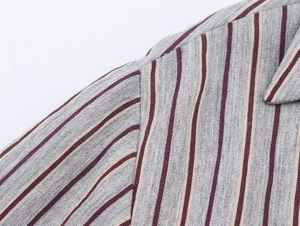 Close-up of vertical burgundy and beige stripes on a gray knit shirt collar