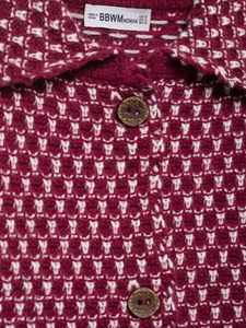 Detail view of burgundy waffle knit cardigan showing brand label and vintage engraved buttons